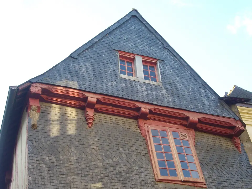 Pignon et toiture en ardoise de la maison « Vannes et sa femme » à Vannes, avec lucarne et consoles peintes en rouge.